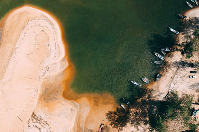 Aerial view of boats moored on shore against sea