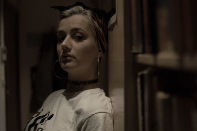 Close-up portrait of young woman standing in darkroom