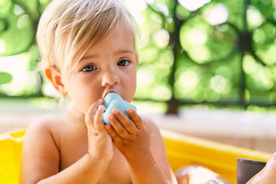 Close-up portrait of shirtless boy looking away