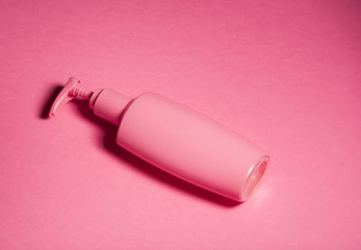 Close-up of bottle against pink background