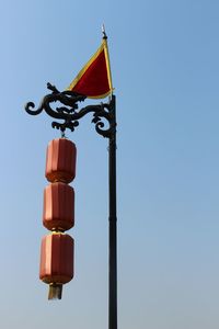 Low angle view of flags against clear blue sky