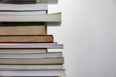 Close-up of stacked books against wall