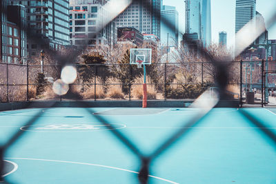 View of basketball hoop against buildings in city
