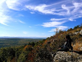 Woman standing by tree against sky