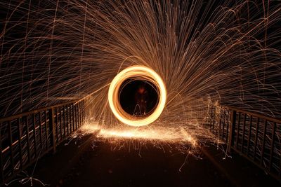 Man spinning wire wool at night