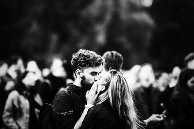 Close-up of young man with woman looking at camera