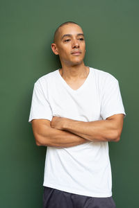 Portrait of young man standing against wall