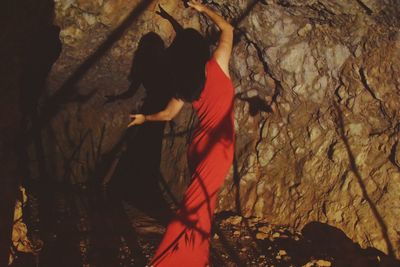 Side view of woman standing in cave