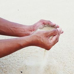 Hands holding sand at beach person