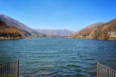 Scenic view of lake against clear blue sky