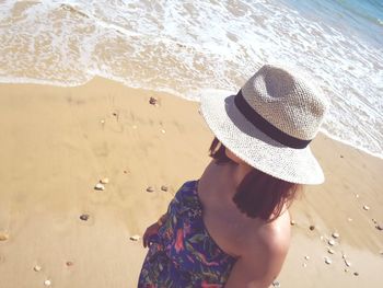 Woman wearing hat standing at beach during summer