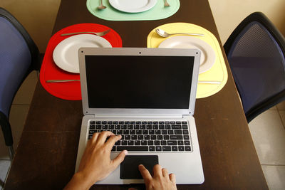 Low section of person using laptop on table