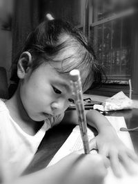 Close-up of girl writing homework at home