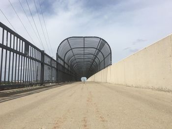 Road by bridge against sky