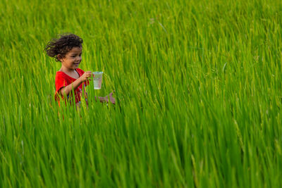 Girl holding glass on grassy field