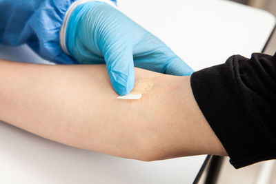 Nurse putting a band-aid on a patient's arm after taking a blood sample