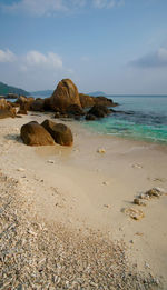 Rocks on beach against sky