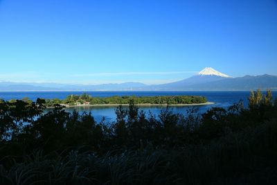 Scenic view of lake against clear blue sky