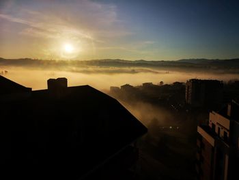 Silhouette buildings against sky during sunset