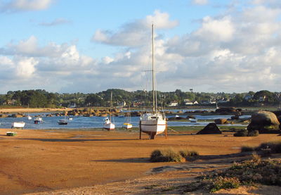 Boats moored at harbor against sky