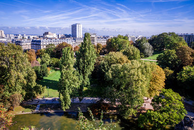 Trees and plants growing in city against sky