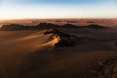 Scenic view of desert against sky during sunset