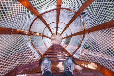 Low section of man standing on rusty ladder