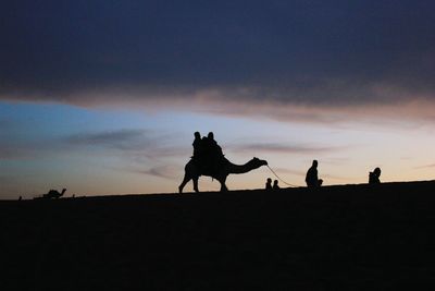 Silhouette of dog against sky at sunset