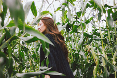 Side view of woman standing by plants