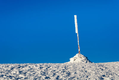 Low angle view of snow covered against blue sky