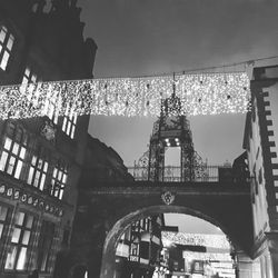 Low angle view of arch bridge in city against sky