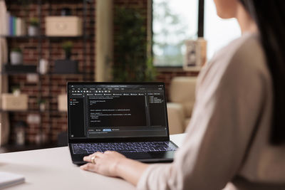 Midsection of woman using laptop