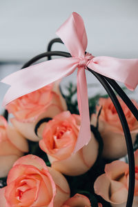 Bouquet of pink roses decorated in hat box on light background. tied bow on top. flower gift for