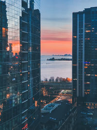 Modern buildings against sky at sunset