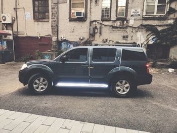 Car parked on street by buildings in city