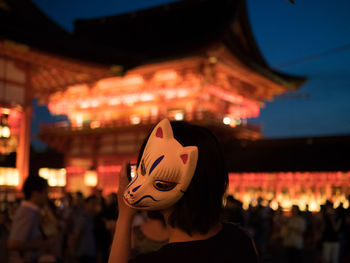 Portrait of woman with light painting in front of building at night