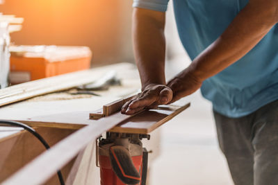 Midsection of man working on table