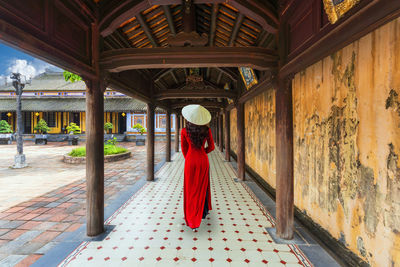 Rear view of woman standing in temple