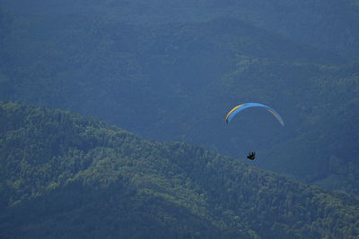 High angle view of man paragliding against mountains