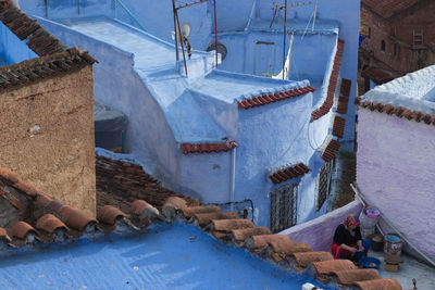 High angle view of woman sitting on building terrace