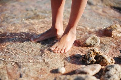 Low section of child standing on rock