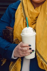 Midsection of woman holding milk shake