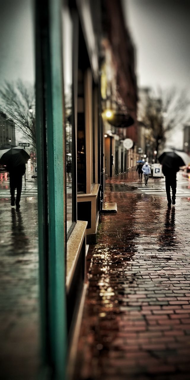 PEOPLE WALKING ON WET STREET IN RAIN
