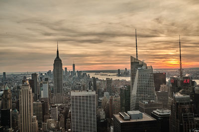 Buildings in city against cloudy sky