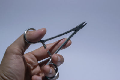 Close-up of hand holding hands against blue background