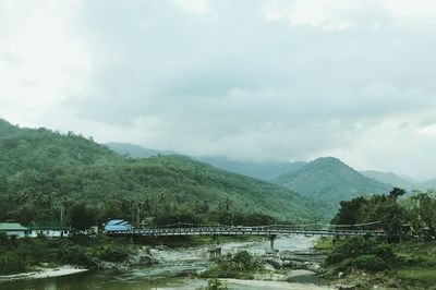 Scenic view of river amidst mountains against sky