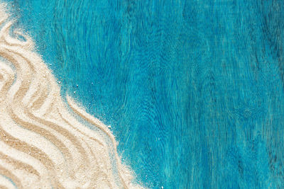 Summer time concept with starfish and sand on a blue wooden background