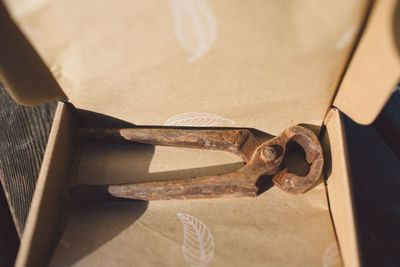 High angle view of old rusty pliers in box