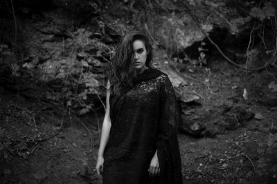 Portrait of young woman standing in forest