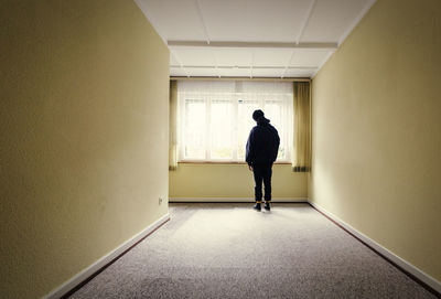 Rear view of man standing in corridor